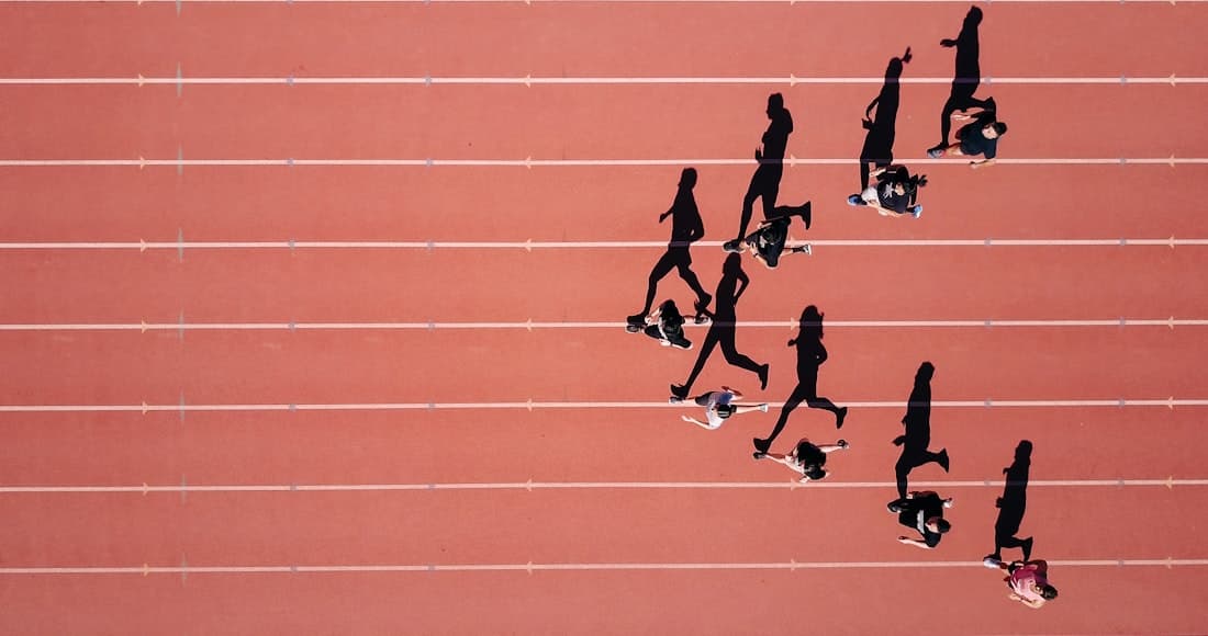 Ilustrativo: corredores a treinar numa pista, vistos de cima